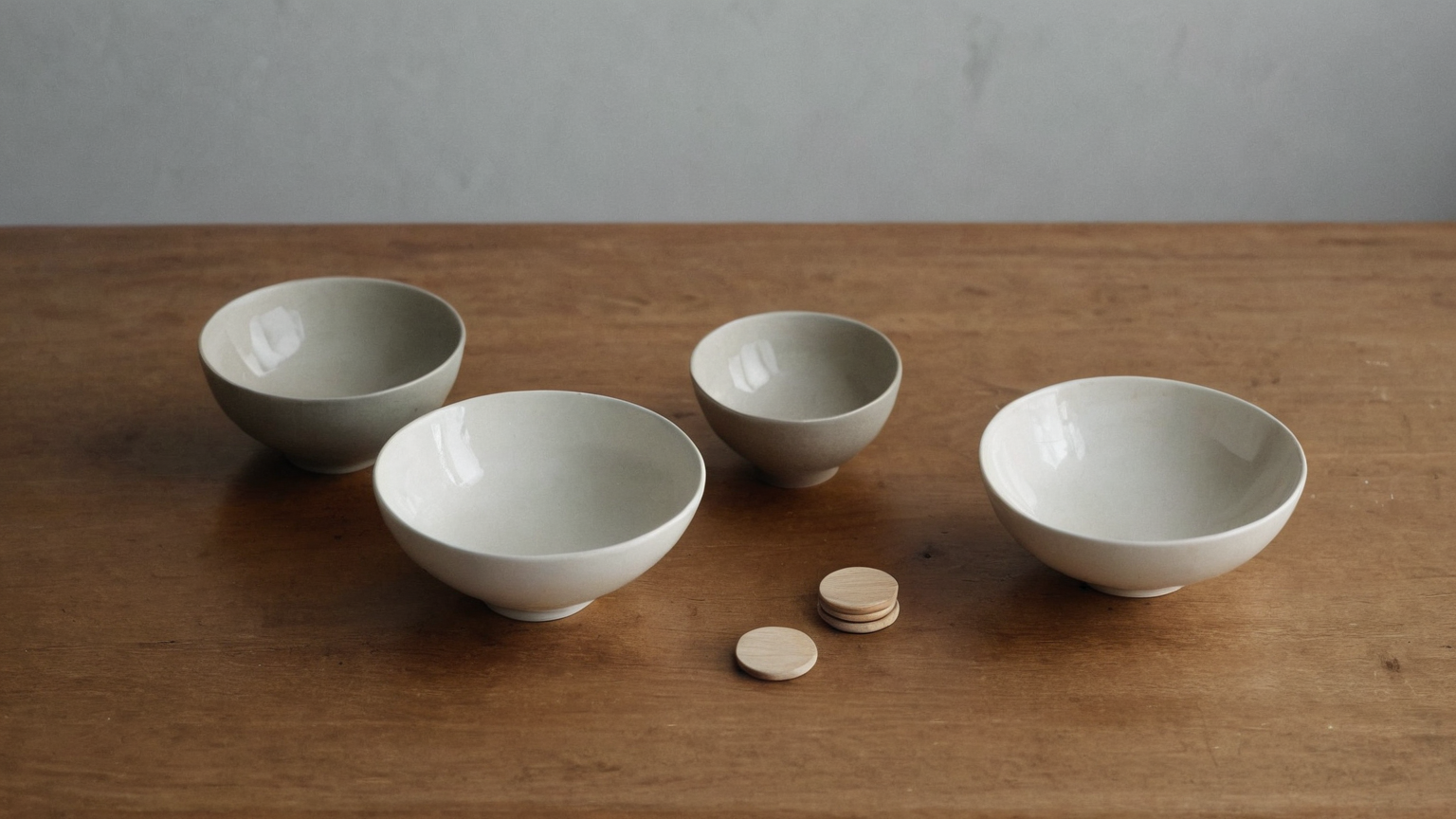 Plain bowls and wooden tokens representing a careful tradeoff comparison